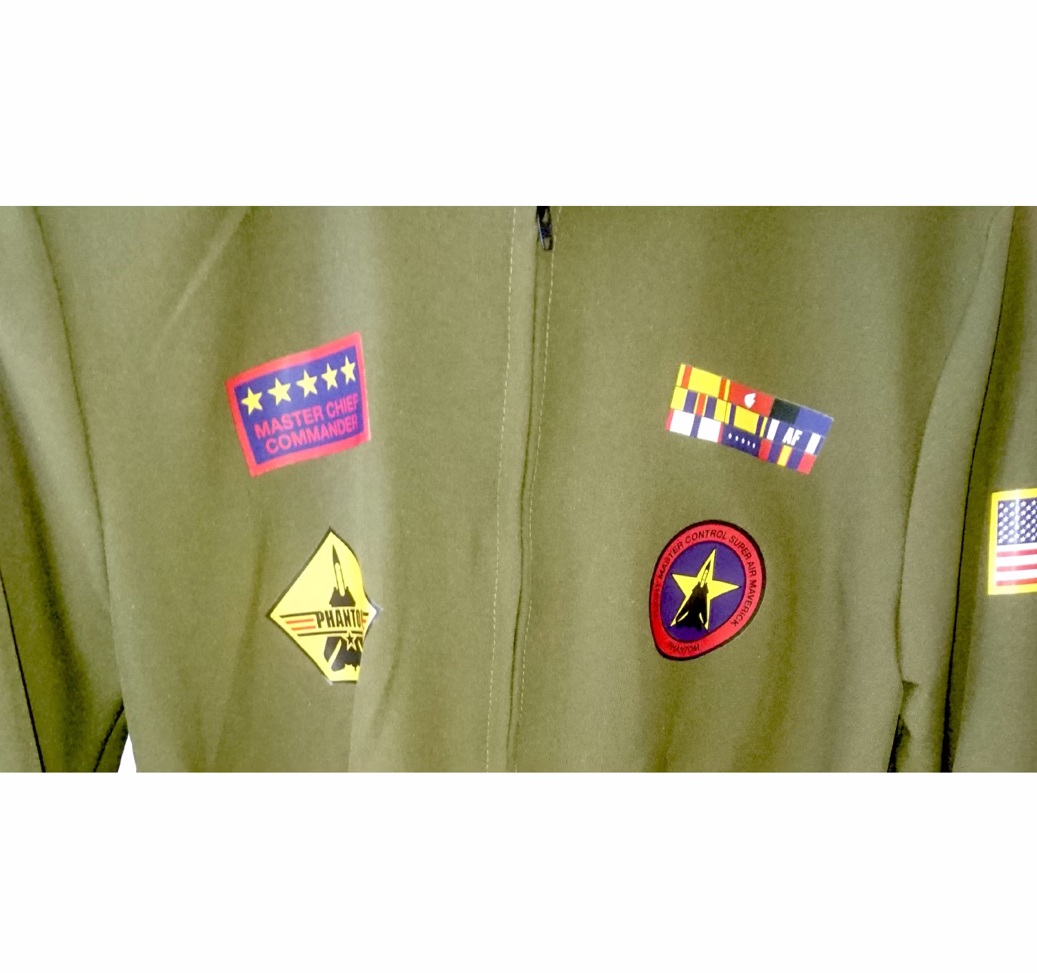 Detailansicht der Vorderseite des olivgrünen Pilotinnen-Overalls mit vier farbigen dekorativen Flieger-Patches.