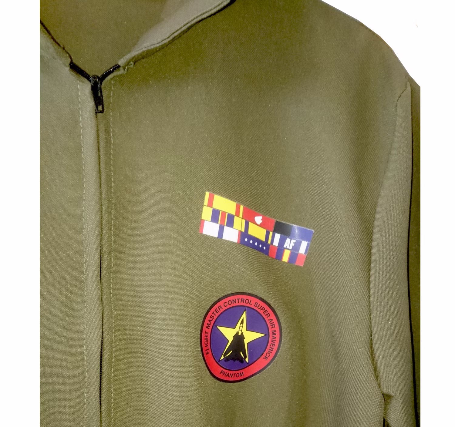 Nahaufnahme des olivgrünen Kampfpilotin Overalls mit Reißverschluss, farbigen Brustabzeichen und dekorativen Flieger-Patches.