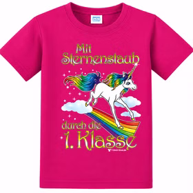 Pinkes Einhorn T-Shirt mit Regenbogenmotiv und Schriftzug „Mit Sternenstaub durch die 1. Klasse“ auf weißem Hintergrund.