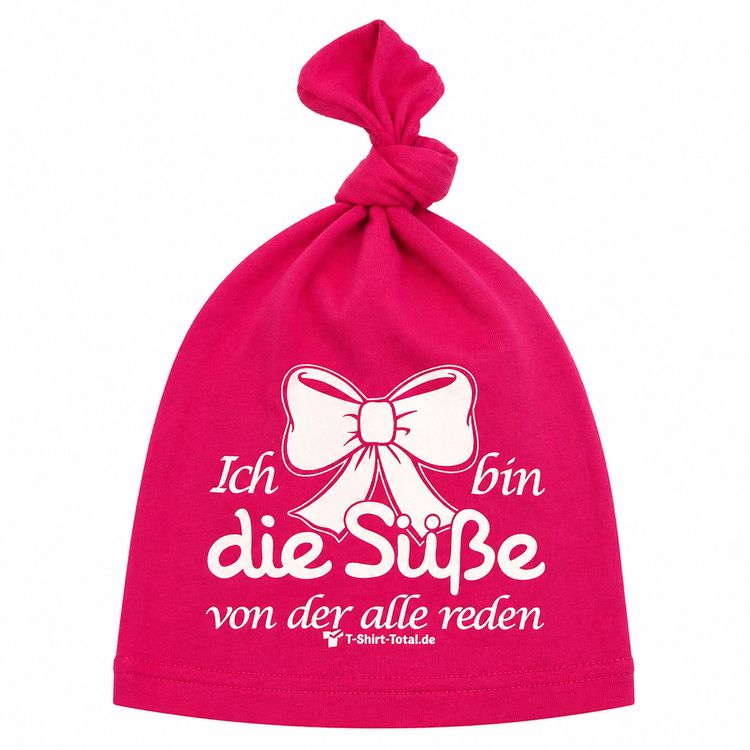Lachendes Baby trägt pinke Beanie Mütze mit Spruch und Schleifenmotiv.