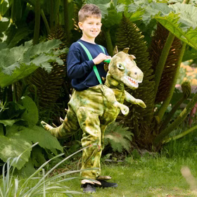 Junge im Garten mit dem Licht-&-Sound-T-Rex Kostüm, als würde er auf dem Dino reiten.