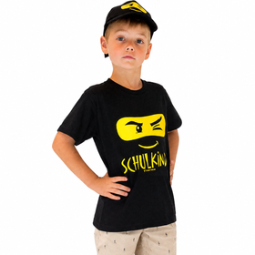 Junge mit Schulkind T Shirt und Basecap hält Zuckertüte und trägt Schulranzen zur Einschulung.