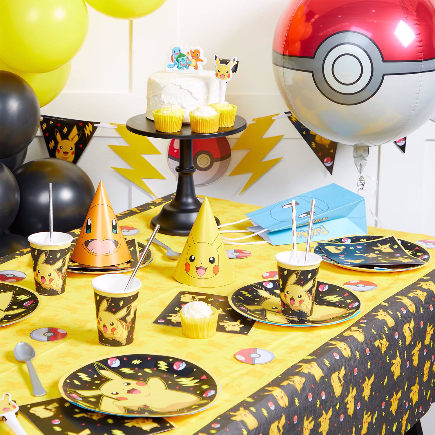 Pokémon Pikachu Kindergeburtstag Tischdekoration Gedeckter Pokémon Partytisch mit Pikachu-Tellern, Bechern, Servietten, Tischdecke, Wimpelkette, Partyhüten und Pokéball-Dekoration.