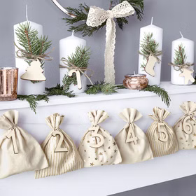 DIY Adventskalender Säckchen zum Befüllen 72-teilig mit Holzzahlen SALE Weihnachten DIY Kalender Geschenkidee Advent Adventszeit Dekorativ aufgehängte Adventskalender-Säckchen mit Holz-Zahlen vor weihnachtlicher Dekoration.