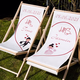 Personalisierte Hochzeits-Liegestühle Mr. & Mrs. mit Wunschname und Hochzeitsdatum individuelles Hochzeitsgeschenk 2 Liegestühle Geschenkidee zur Hochzeit Gastgeschenk Hochzeitsfeier Schrägansicht von zwei personalisierten Hochzeits-Liegestühlen mit Namen Timo, Jasmin und Datum 09.06.2021.