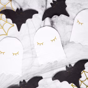 Mehrere Gespenster-Servietten als Halloween-Tischdekoration kombiniert mit Fledermausmotiven und Spinnennetz-Deko.