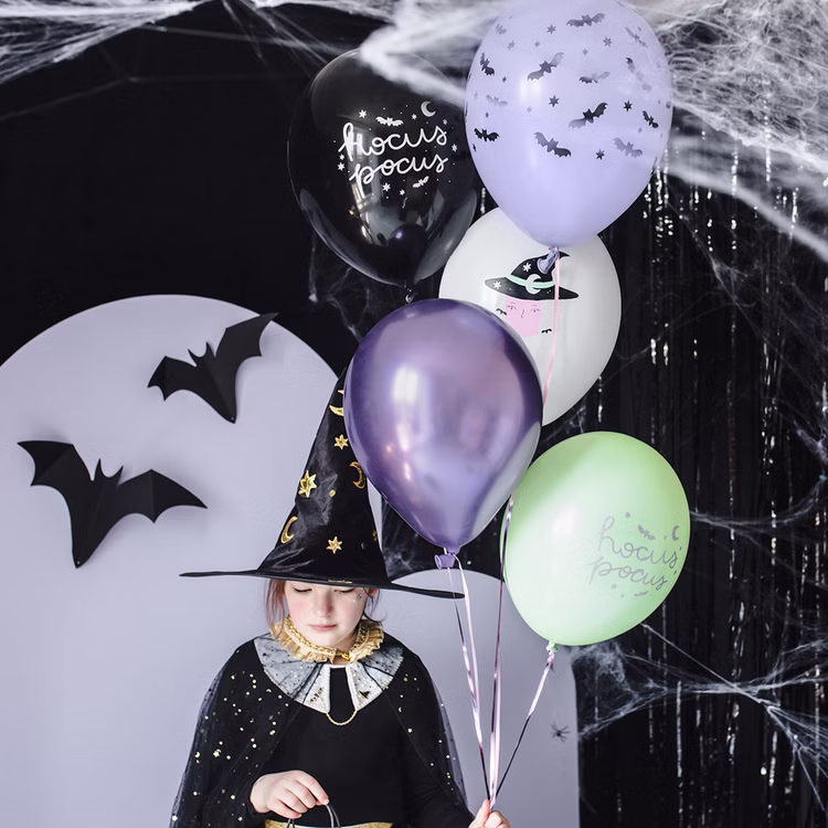 Halloween Luftballons Hexe Hocus Pocus 6 Stück Ø 30 cm Partydeko Raumdeko Dekoration SALE Halloween Party Mottoparty Hexenparty Gruselparty Halloween-Luftballons als Dekoration neben verkleidetem Mädchen und passender Partydekoration.