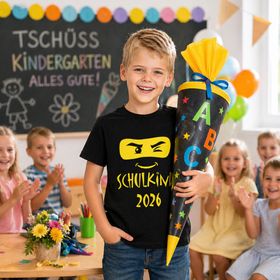 Schwarzes Kinder T-Shirt „Schulkind 2026“ mit gelbem Ninja-Gesicht und Schriftzug auf weißem Hintergrund.