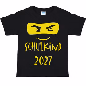Schwarzes Kinder-T-Shirt mit gelbem Ninja-Gesicht, zwinkerndem Auge und dem Schriftzug „Schulkind 2027“ auf der Vorderseite.