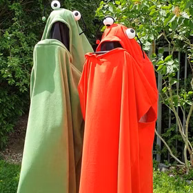 Grünes und Rotes Monster Kostüm stehen im Garten