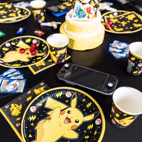 Pokémon Pappteller 8 Stück Ø 23 cm Pikachu Partygeschirr Geburtstag Deko Partyzubehör Kindergeburtstag gedeckter Tisch Gedeckter Pokémon-Partytisch mit Pikachu-Tellern, passenden Bechern und Servietten sowie Geburtstagstorte und Spielkonsole.