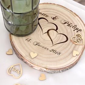 Baumscheibe mit Gravur Doppelherz Namen und Datum Hochzeit Jahrestag Holzscheibe Geschenkidee Brautpaar Hochzeitsgeschenk Personalisierte Baumscheibe von Oben mit Streuherzen dekoriert.