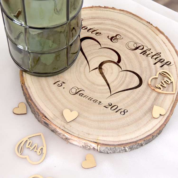 Baumscheibe mit Gravur Doppelherz Namen und Datum Hochzeit Jahrestag Holzscheibe Geschenkidee Brautpaar Hochzeitsgeschenk Personalisierte Baumscheibe von Oben mit Streuherzen dekoriert.