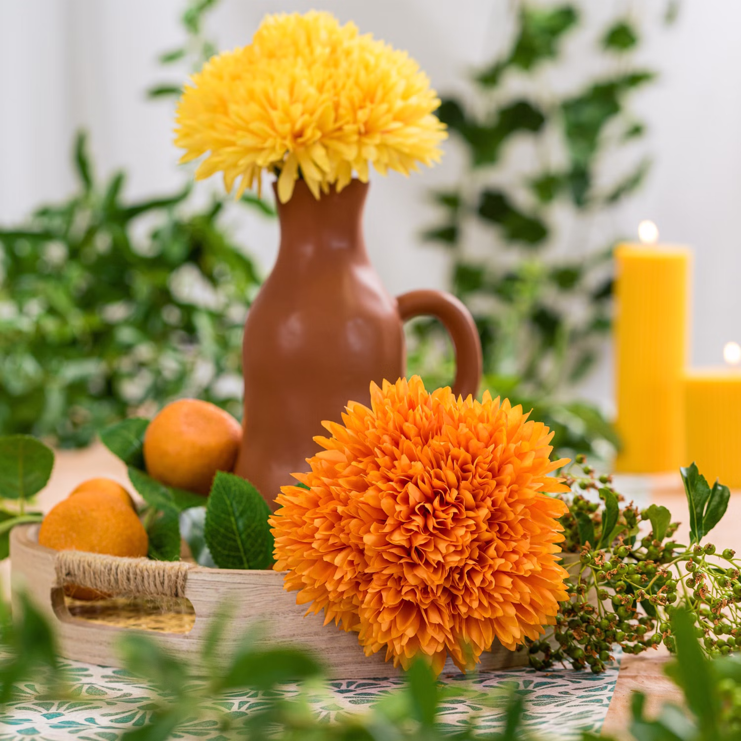 Kunstblumen Dahlien Mandarine Orange Mediterrane Tischdeko Orangefarbene künstliche Dahlien mit Mandarinen, grünen Blättern und brauner Keramikvase als sommerliche Tischdekoration.