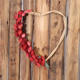Rattan-Herzen 2er Set Natur 38 & 33 cm Deko-Herzen zum Basteln SALE Hochzeit Dekoration Bastelbedarf Türdeko Geschenk Großes Rattan-Herz hängt an einer Holzwand und ist dekorativ mit roten Trockenblumen geschmückt.