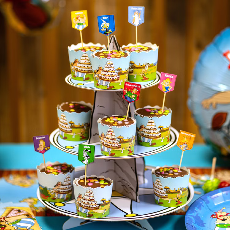 XXL Asterix & Obelix Geburtstag Party-Set Tisch-Deko 65-tlg. Part-Deko Kindergeburtstag Comic-Helden Dekoration gedeckter Tisch Mehrstöckiger Cupcake-Ständer mit Asterix-Muffinformen und dekorativen Figurensteckern für eine Comic-Mottofeier.