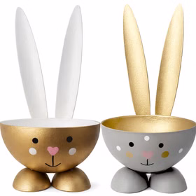 Zwei Hasen-Eierbecher aus Metall: links gold, rechts grau mit weißen Punkten und goldfarbenem Innenraum.