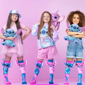 Drei Kinder posieren gemeinsam in pinkfarbener Umgebung und tragen die Stitch-&-Angel-Socken mit 3D-Ohren sowie passende Stitch-Kleidung.