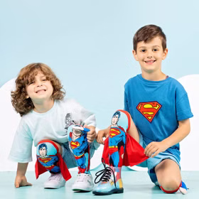 Lustige Superman Socken Blau Rot Superheld mit 3D-Effekt für Kinder & Erwachsene Kniestrümpfe Geschenkidee Kindersocken Socken für Erwachsene Spaßsocken Kostüm-Zubehör Kniestrümpfe Geschenkidee Kindersocken Socken für Erwachsene Spaßsocken Kostüm-Zubehör Zwei Kinder knien und präsentieren lachend die Superman-Socken mit Cape.