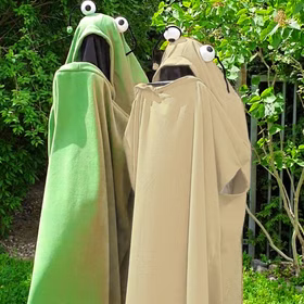Grünes und Eierfarbenes Monster Kostüm stehen im Garten