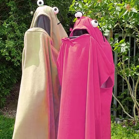 Monster Kostüm Kuki Pink für Erwachsene Onesize Damen und Herren Paar- und Gruppenkostüm Fasching Karneval Mottoparty Halloween Eierfarbenes und Pinkes Monster Kostüm stehen im Garten