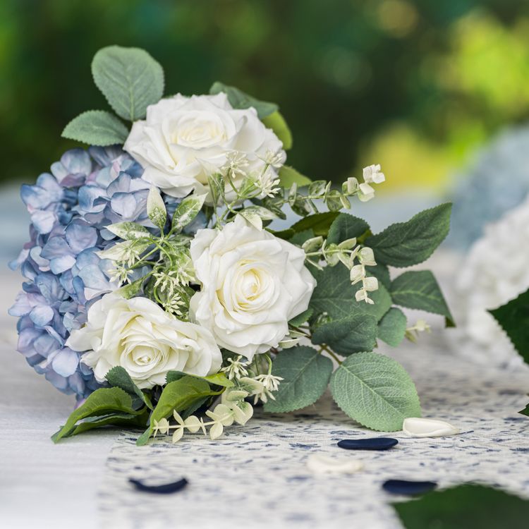 Strauß aus weißen Rosen, blauen Hortensien und grünen Blättern, Nahaufnahme.