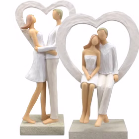 Zwei Figuren: ein Paar im Herzrahmen stehend und ein Paar sitzend, nebeneinander aufgestellt.