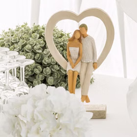 Hochzeitsfigur Brautpaar im Herzrahmen als Tischdeko mit Gläsern und Blumen.