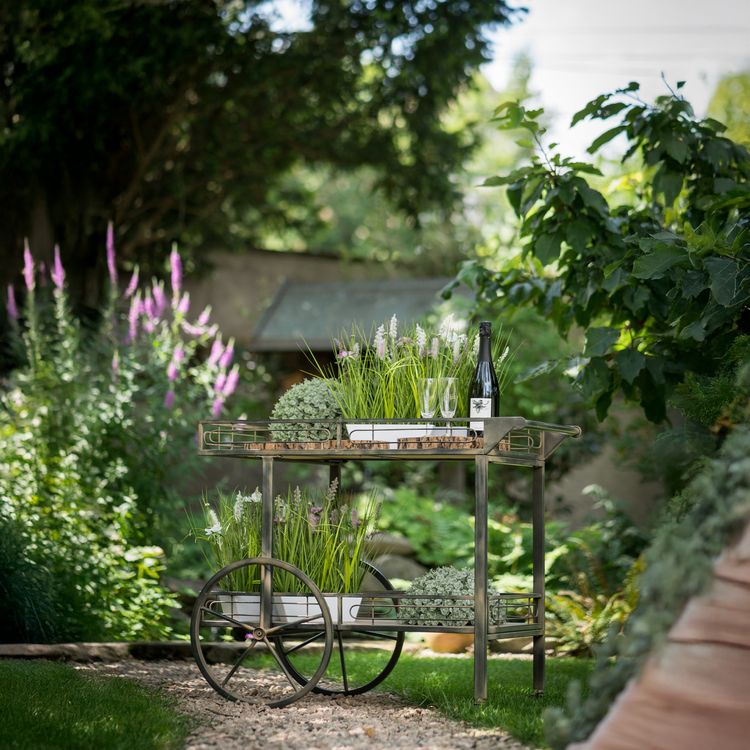 Vintage Servierwagen steht im Garten auf dem Rasen seitlich von Vorne