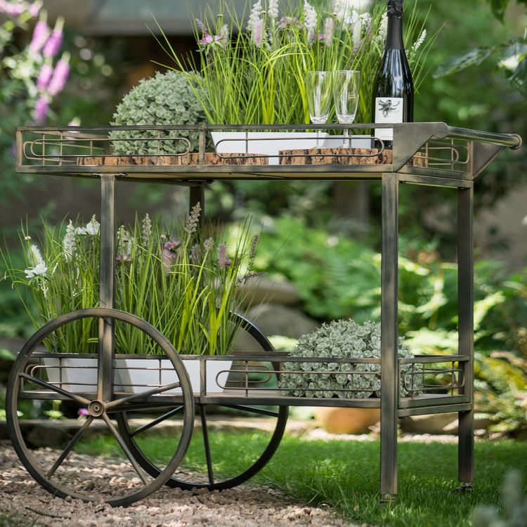 Vintage Servierwagen steht im Garten auf dem Rasen seitlich von Vorne