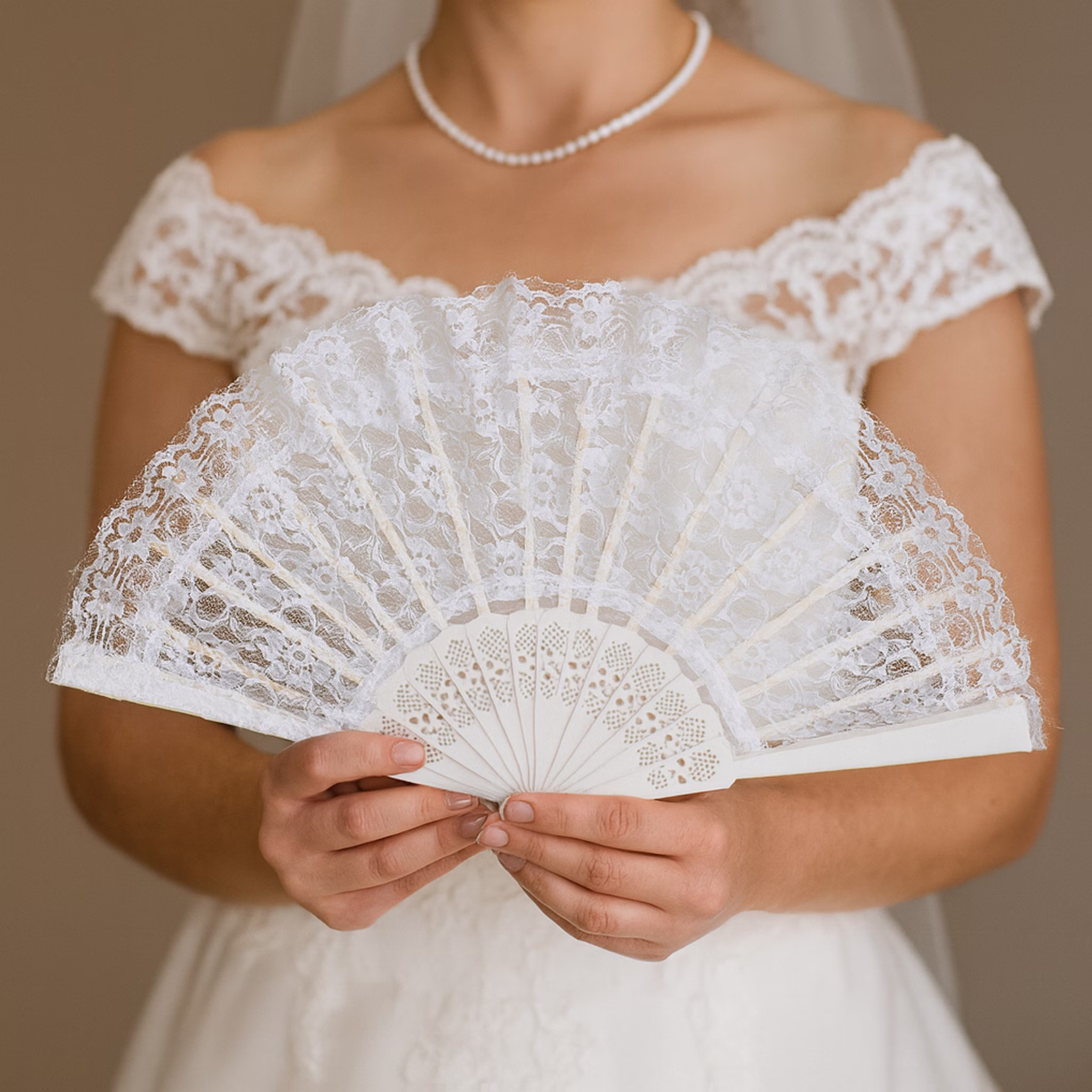 Eleganter weißer Spitzenfächer aufgeklappt in den Händen einer Braut von Vorne