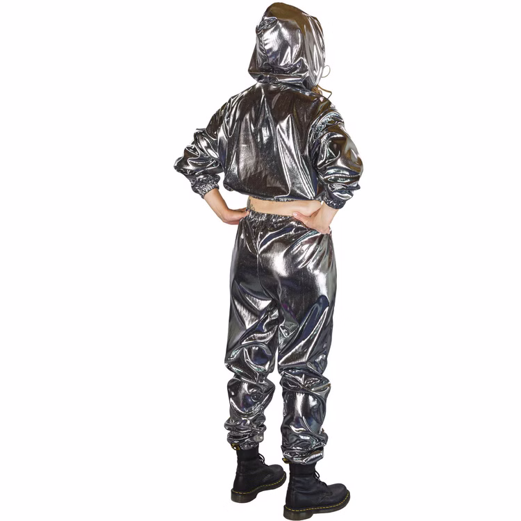 90er Jahre Space Kostüm Silver Flash Rave für Erwachsene Gr. M-XL Paarkostüm Gruppenkostüm Fasching Karneval 80er und 90er Mottoparty Rückansicht einer Frau im silbernen Jogginganzug mit Kapuze, die Hände in die Hüften gestützt.