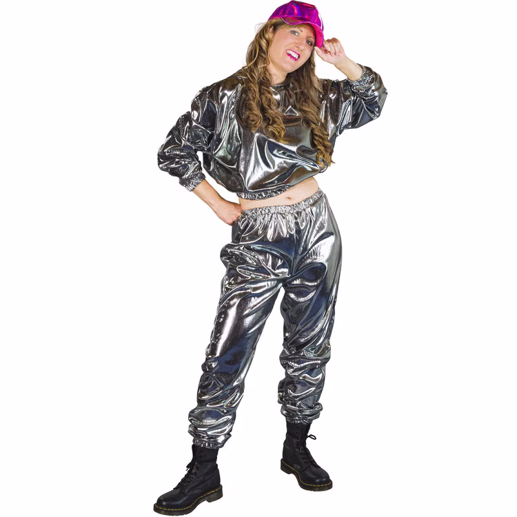 90er Jahre Space Kostüm Silver Flash Rave für Erwachsene Gr. M-XL Paarkostüm Gruppenkostüm Fasching Karneval 80er und 90er Mottoparty Frau trägt glänzenden silbernen Jogginganzug mit pinker Kappe und schwarzen Boots, steht seitlich und lächelt.