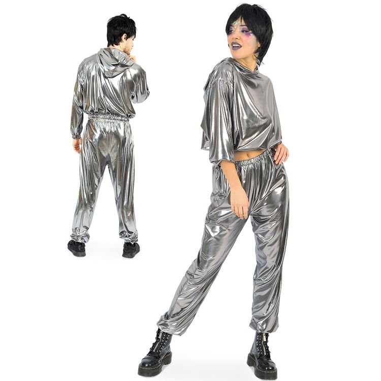 Mann und Frau tragen silberne Jogginganzüge mit Kapuze, er steht mit pinker Cap und Getränk, sie hockt mit auffälligem Make-up.