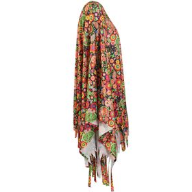Frau im bunten Hippie-Poncho mit Stirnband; Blick über die Schulter, Fransen, Jeans und Sandalen.