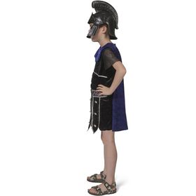 Kind im Gladiator-Kostüm mit schwarzer Tunika, lila Umhang, Helm, Schild und Schwert von Vorne.