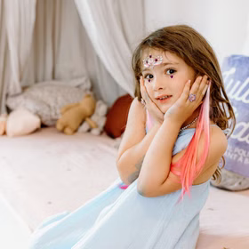 Bunte Haarsträhnen mit Clip 8 Stück Pink & Lila Prinzessin Fee Extensions für Kinder Geschenkidee Geburtstag Fasching Karneval Rollenspiel Verkleidung Mädchen mit bunten Haarsträhnen in Pink posiert im blauen Kleid mit Schmuck und glitzernden Accessoires.