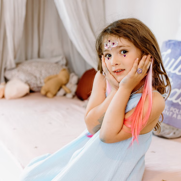 Bunte Haarsträhnen mit Clip 8 Stück Pink & Lila Prinzessin Fee Extensions für Kinder Geschenkidee Geburtstag Fasching Karneval Rollenspiel Verkleidung Mädchen mit bunten Haarsträhnen in Pink posiert im blauen Kleid mit Schmuck und glitzernden Accessoires.