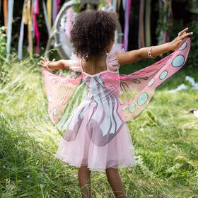 Schmetterling Kostüm Fee Rosalie Kleid mit Flügeln für Kinder 5-6 Jahre Tierkostüm Fasching Karneval Mottoparty Kindergeburtstag Ein Mädchen zeigt die ausgebreiteten Flügel des rosa Schmetterlingskostüms von hinten.