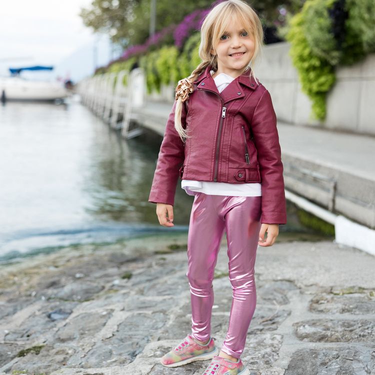 Eine glänzende pinkfarbene Kinderleggings liegt einzeln gefaltet auf weißem Hintergrund.