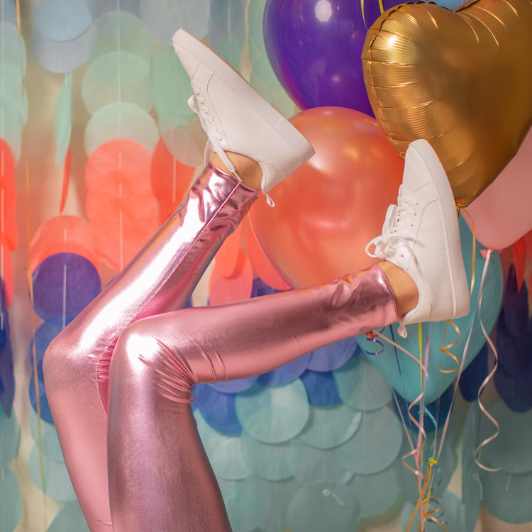 Leggings Rosa Metallic Fee Prinzessin Kostüm-Zubehör für Kinder 3-8 Jahre Kostüm-Zubehör Fasching Karneval Mottoparty Geburtstag Kinderfasching Beine in pinkfarbener Metallic-Leggings und weißen Turnschuhen, hochgestreckt vor bunten Luftballons.