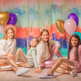 Leggings Gold Metallic Fee Reh Kostüm-Zubehör für Kinder 3-8 Jahre Kostüm-Zubehör Fasching Karneval Mottoparty Vier Mädchen tragen Metallic-Leggings in Pink und Gold, posieren lächelnd vor einer bunten Kulisse mit Luftballons.