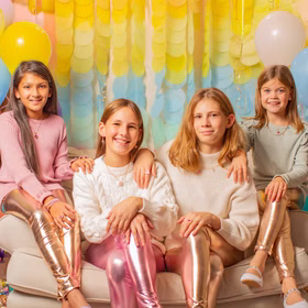 Leggings Gold Metallic Fee Reh Kostüm-Zubehör für Kinder 3-8 Jahre Kostüm-Zubehör Fasching Karneval Mottoparty Mädchen sitzt auf Sofa – Vier Mädchen tragen Metallic-Leggings in Gold und Pink und sitzen fröhlich zusammen auf einem Sofa.