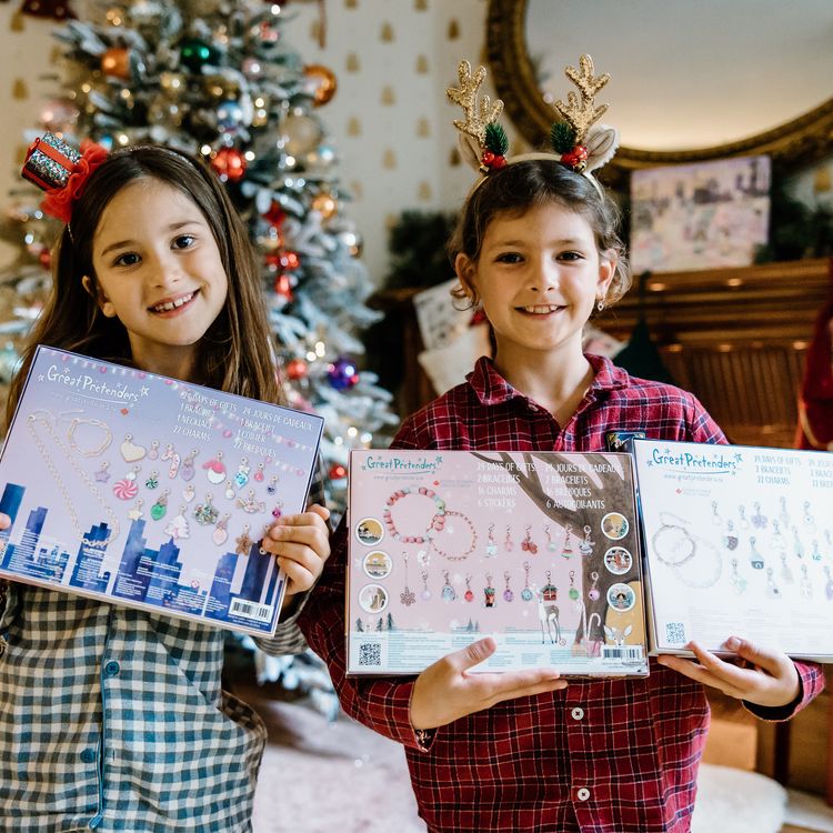 Schmuck Adventskalender Armband & Kette 22 Anhänger Weihnachts-Party für Kinder Adventskalender mit geöffnetem Türchen, davor die enthaltenen Schmuckteile dekorativ angeordnet.