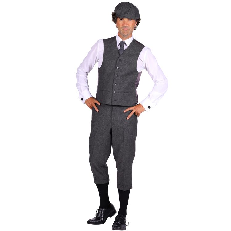 Ein Mann trägt eine graue Knickerbocker-Hose, kombiniert mit Weste, weißem Hemd, Krawatte, Kniestrümpfen und schwarzen Schuhen.
