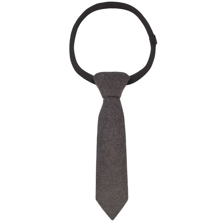 Nahaufnahme eines Mannes im grauen Anzug mit weißem Hemd, grauer Krawatte und Schiebermütze.