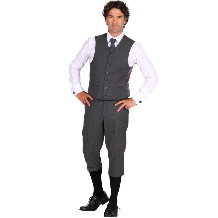Ein Mann trägt ein komplettes Kostüm im 20er-Jahre-Stil mit grauer Weste, Knickerbockerhose, weißem Hemd, schwarzer Krawatte und schwarzen Schuhen.