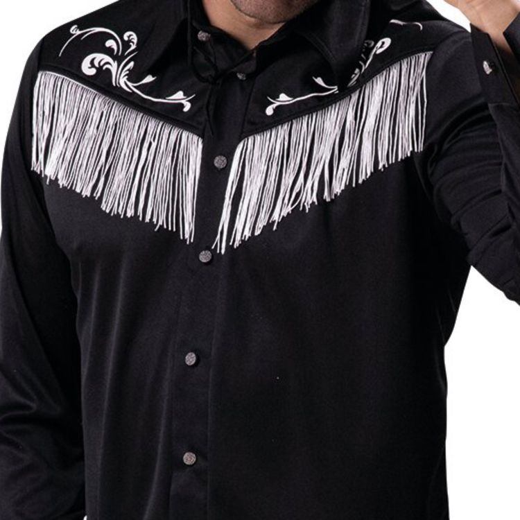 Mann mit schwarzem Cowboyhemd, hellblauer Jeans und schwarzem Cowboyhut, lächelt und tippt mit der Hand an den Hut.