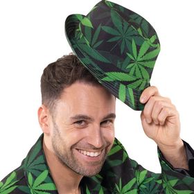 Ein Mann trägt einen Fedora-Hut mit grünem Hanfblattmuster und schaut lachend nach unten.