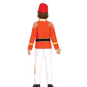 Kind trägt rotes Nussknacker-Kostüm mit goldenen Verzierungen und weißer Hose.